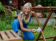 A senior woman cleaning garden furniture and getting the garden ready for summer